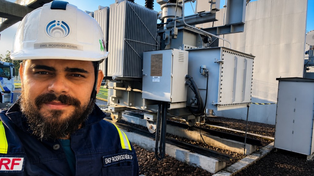 Engenheiro em campo com capacete RSI e transformador Siemens ao fundo